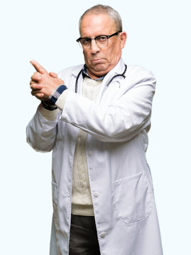Handsome senior doctor man wearing medical coat Holding symbolic gun with hand gesture, playing killing shooting weapons, angry face