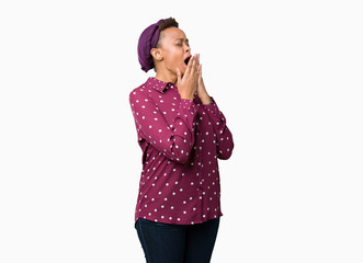 Fototapeta premium Beautiful young african american woman wearing head scarf over isolated background bored yawning tired covering mouth with hand. Restless and sleepiness.