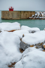 Rocks covered by snow in frot of the ocean