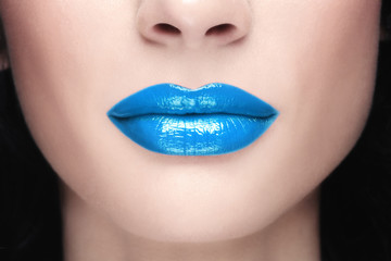 Close-up shot of woman lips with glossy blue lipstick