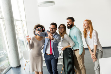 Young happy business people letting the drone camera to fly over the office and having fun