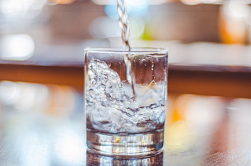 Water pouring into glass transparent