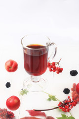autumn warming tea with berries on a white wooden background