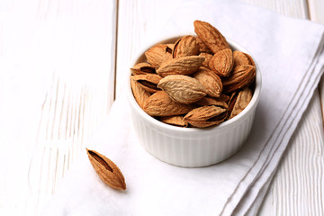 almonds in shell on a white wooden background