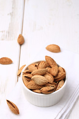 almonds in shell on a white wooden background