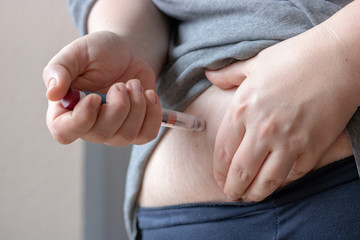 Plus size woman injecting insulin into fat stomach, diabetes, health problems