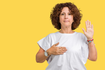 Beautiful middle ager senior woman wearing white t-shirt over isolated background Swearing with...