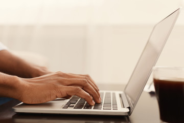 Black man hands typing on laptop keyboard