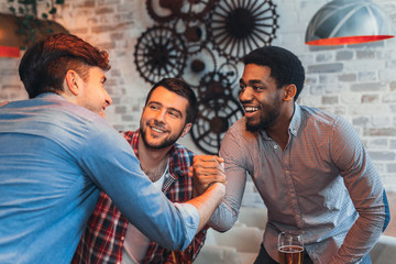 Multiracial friends greeting each other in beer pub © Prostock-studio