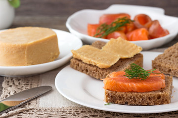 Traditional Norwegian breakfast, sandwiches with brown cheese brunost, sandwiches with cucumber and trout.
