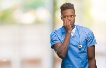 Young african american doctor man over isolated background wearing surgeon uniform looking stressed and nervous with hands on mouth biting nails. Anxiety problem.