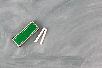 Back to school concept with green chalkboard plus eraser and chalk