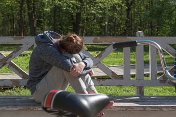 Girl cyclist resting on a bench in the park