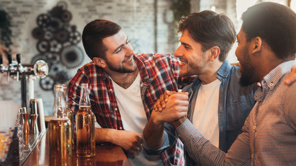 Male friends meeting in pub, drinking beer
