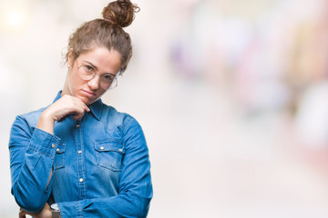 Beautiful young brunette curly hair girl wearing glasses over isolated background thinking looking tired and bored with depression problems with crossed arms.