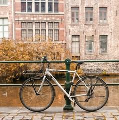 Bicycles standing near canal with European building on a autumn day.