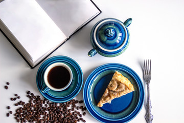 Open book with blank pages, coffee with banana pie.