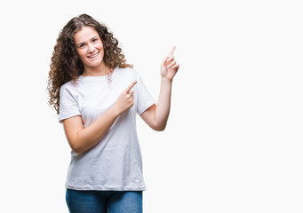 Beautiful brunette curly hair young girl wearing casual t-shirt over isolated background smiling and looking at the camera pointing with two hands and fingers to the side.