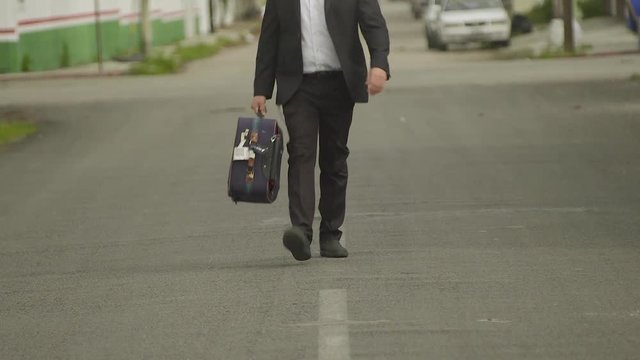 business man or rabbi in suit walk with suitcase on a road in mexican street