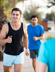 Fototapeta premium Smiling sportsmen are joggning race in time warm-up