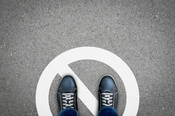 Black shoes standing on the wrong place that prohibited and not allowed