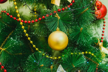 decorations on an artificial green christmas pine tree at home