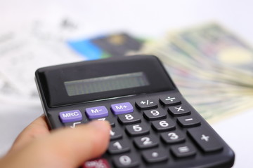 Obraz premium 手に持った電卓(お金、クレジットカード等の背景)