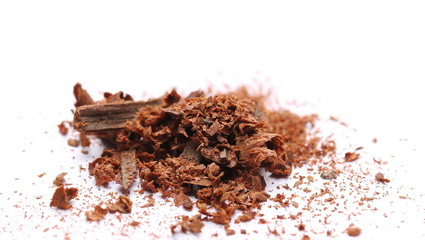 Cinnamon sticks with powder and shavings, macro isolated on white background