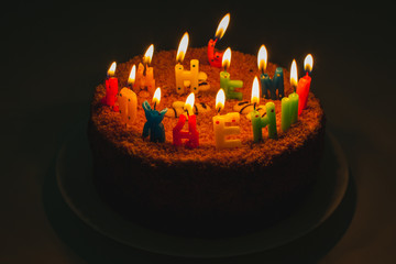 a birthday cake with letter shaped candles in russian "Happy birthday to you"