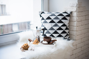 Cozy winter home arrangement on windowsill, coffee and cookies o