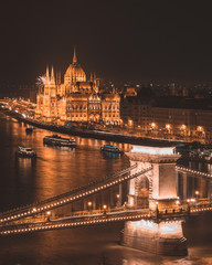 Fototapeta na wymiar Panorama of the Hungarian Parliament, and the Szechenyi Chain bridge over the River Danube, Budapest, Hungary, at night
