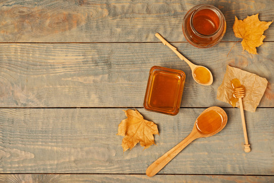 Flat lay composition with honey on wooden background. Space for text