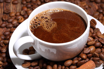 close up coffee cup and grains on wooden table