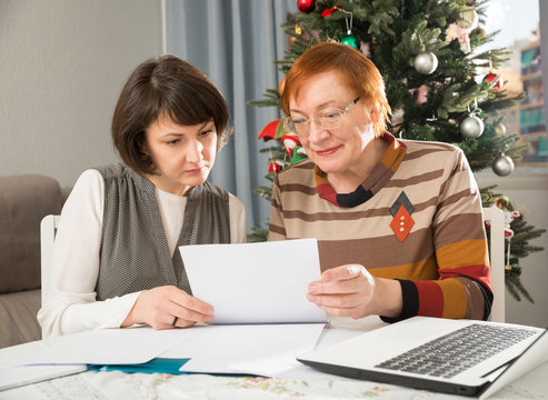 Senior woman with daughter writing papers