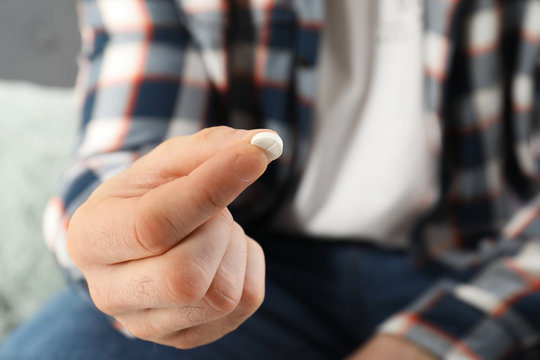 Man holding pill in hand, closeup view. Health care