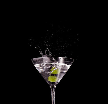 olives splash in a martini on black