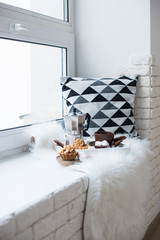 Cozy winter home arrangement on windowsill, coffee and cookies o