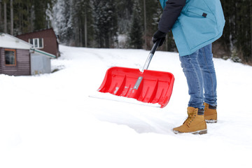 Man removing snow with shovel near house. Space for text