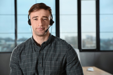 Male technical support operator with headset in office. Space for text