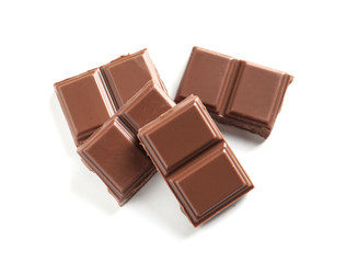 Pieces of tasty milk chocolate on white background, top view