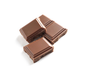 Pieces of tasty milk chocolate on white background