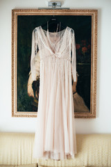 The bride's dress hangs against the background of the picture in the room