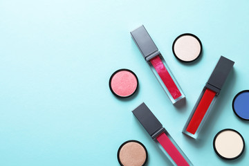 Composition of lipsticks and eyeshadows on color background, flat lay. Space for text