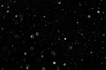 a bokeh of white snow on a black background
