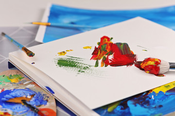 Hobby ,Painting, Art, Creativity concept. Artistic equipment : brushes, tubes of paint, palette and paintings on the table