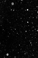 Bokeh white snow on a black night background