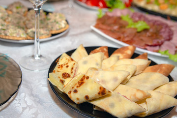 The festive table is served for the holiday of Maslenitsa. Rolls of pancakes with sturgeon. Various dishes of Russian cuisine on the table