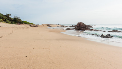 Fototapeta na wymiar Beach Ocean Fishermen Rocky Coastline Landscape