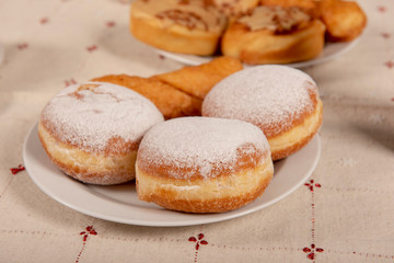 Sugared doughnut on a white plate in a kitchen setting 