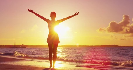 Freedom woman with open arms silhouette in sunrise against sun flare. Morning yoga girl practicing sun salutation outdoors. Carefree person living a free life. Success freedom happy life concept. - Powered by Adobe